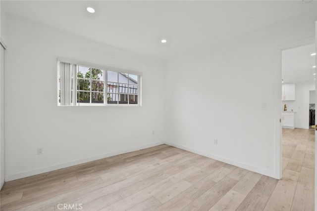 unfurnished room featuring recessed lighting, baseboards, and light wood-style floors