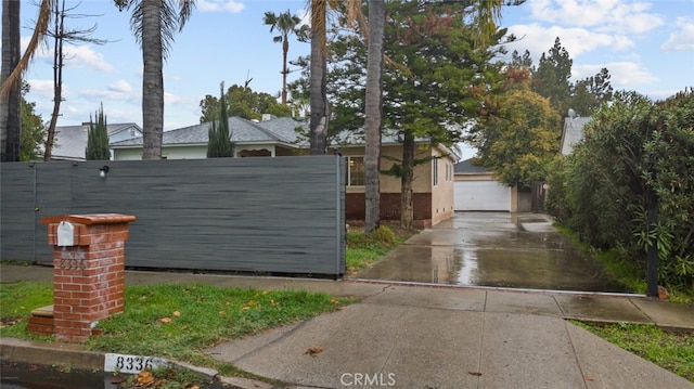 view of home's exterior featuring a gate, a detached garage, and fence