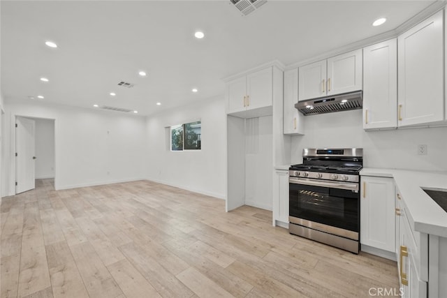 kitchen with gas range, light countertops, visible vents, and under cabinet range hood