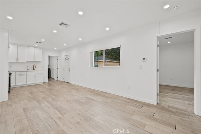 unfurnished living room featuring recessed lighting, visible vents, baseboards, and light wood finished floors