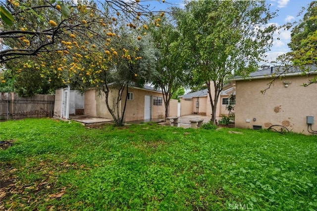 view of yard featuring a patio area, fence, and an outdoor structure