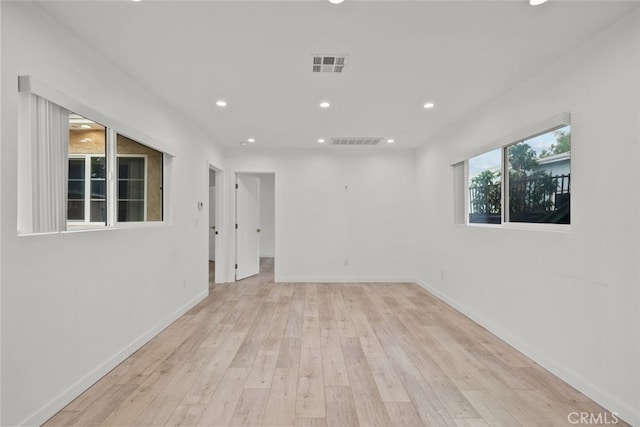 unfurnished room with visible vents, recessed lighting, baseboards, and wood-type flooring