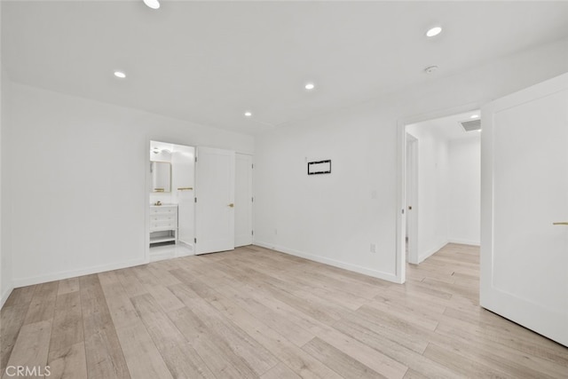 empty room featuring recessed lighting, light wood-style floors, visible vents, and baseboards