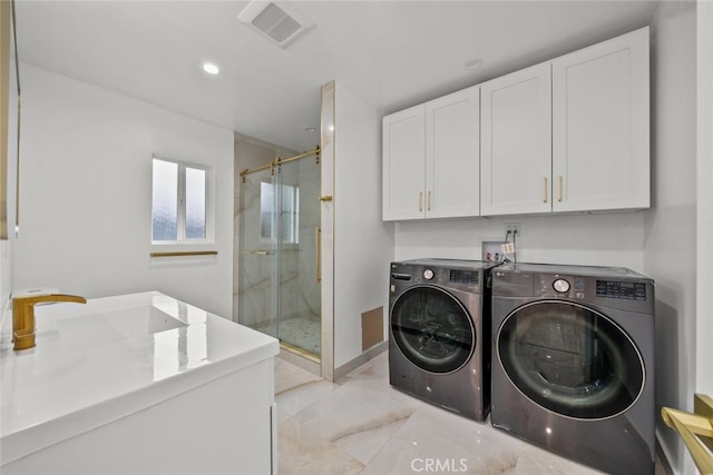 clothes washing area featuring visible vents, separate washer and dryer, cabinet space, marble finish floor, and a sink