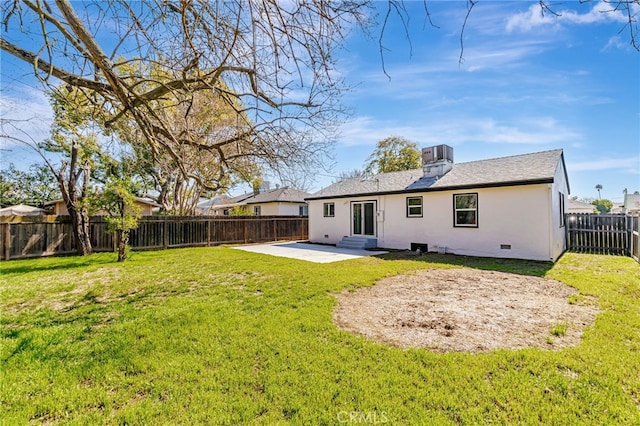 rear view of house featuring a fenced backyard, stucco siding, entry steps, a patio area, and a lawn