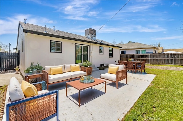 back of house with stucco siding, a lawn, a fenced backyard, outdoor lounge area, and a patio area