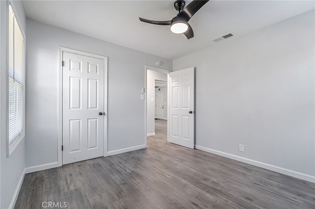 unfurnished bedroom featuring visible vents, baseboards, wood finished floors, and a ceiling fan