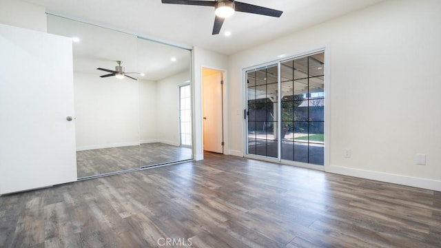 unfurnished bedroom featuring access to exterior, multiple windows, and wood finished floors