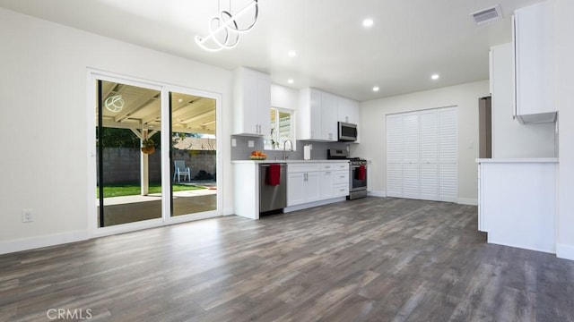 kitchen with white cabinetry, dark wood finished floors, visible vents, and stainless steel appliances