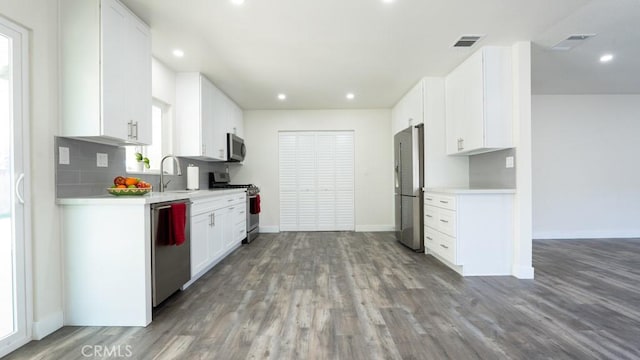 kitchen featuring wood finished floors, visible vents, a sink, light countertops, and appliances with stainless steel finishes