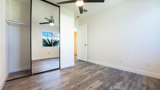 unfurnished bedroom with a ceiling fan, wood finished floors, visible vents, baseboards, and a closet