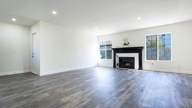 unfurnished living room featuring recessed lighting, a fireplace, dark wood-style flooring, and baseboards