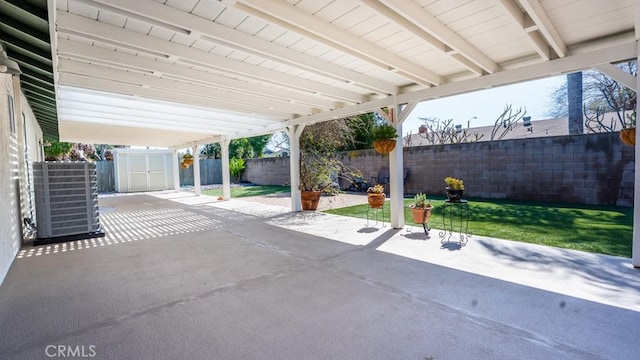 view of patio with a storage shed, central AC unit, a fenced backyard, and an outdoor structure