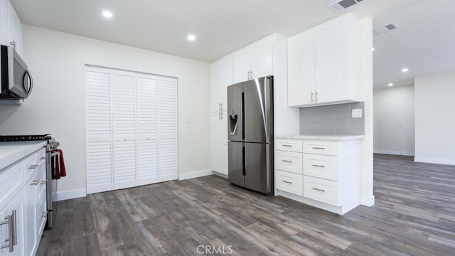 kitchen with light countertops, dark wood-style floors, visible vents, and appliances with stainless steel finishes