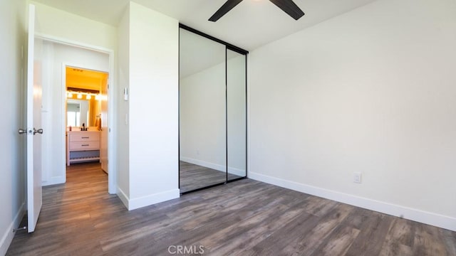 unfurnished bedroom with a ceiling fan, baseboards, lofted ceiling, dark wood-type flooring, and a closet