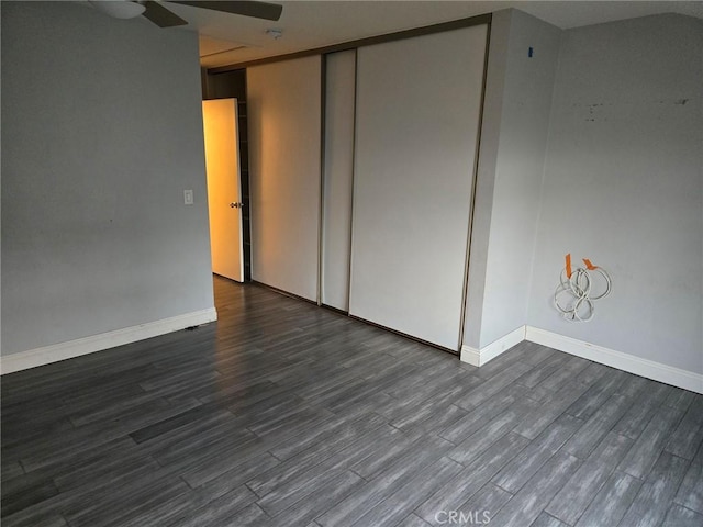 empty room with baseboards and dark wood-style floors