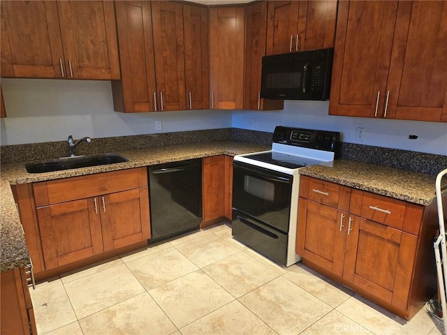 kitchen featuring dark stone counters, brown cabinets, light tile patterned flooring, black appliances, and a sink