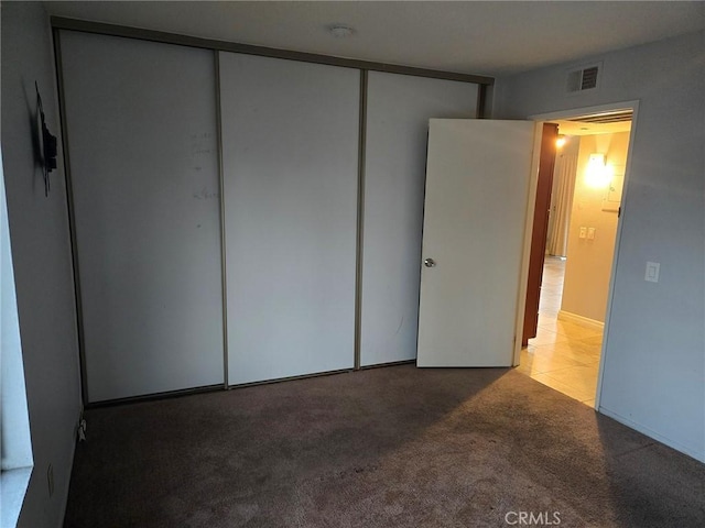 unfurnished bedroom with a closet, visible vents, and carpet flooring