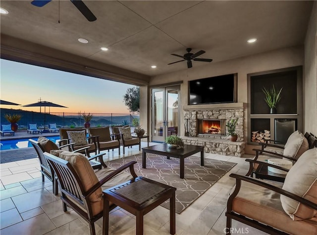 view of patio / terrace featuring an outdoor living space with a fireplace, fence, and a fenced in pool