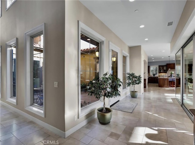 hallway with recessed lighting, baseboards, visible vents, and light tile patterned floors