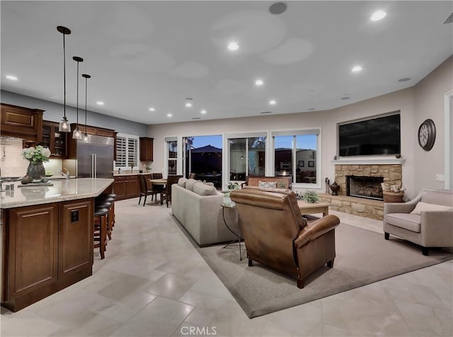 living room with recessed lighting, visible vents, and a stone fireplace