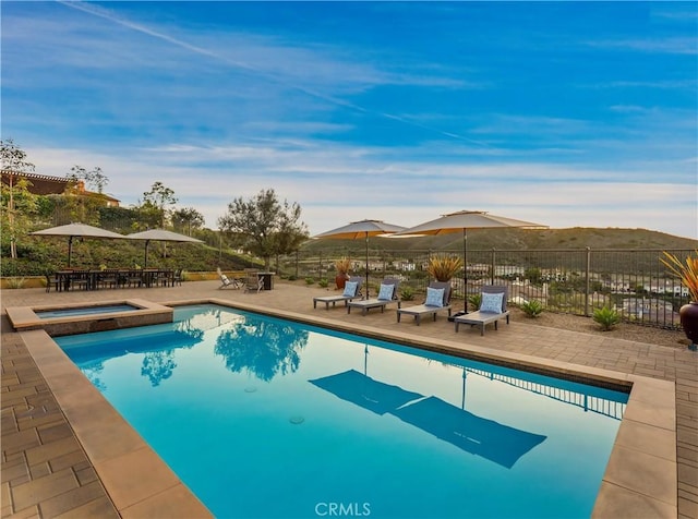 view of swimming pool featuring a patio area, a fenced in pool, an in ground hot tub, and fence