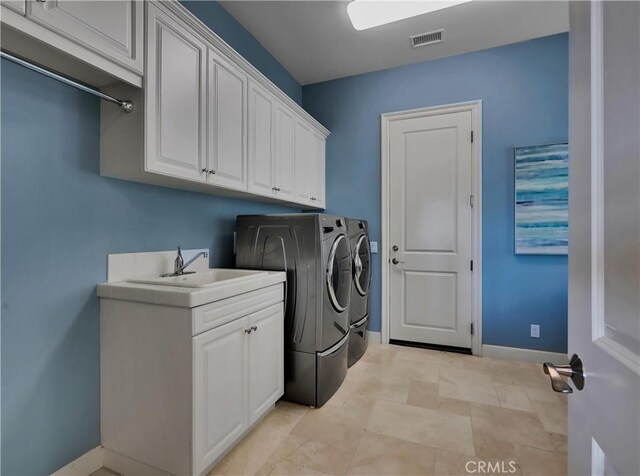 laundry room with washing machine and clothes dryer, cabinet space, a sink, baseboards, and visible vents