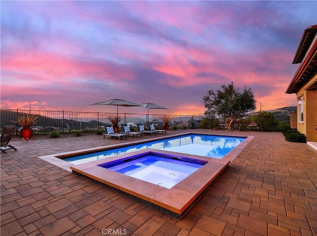 view of pool with a fenced backyard, a fenced in pool, an in ground hot tub, and a patio