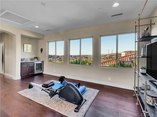 workout area with beverage cooler, visible vents, dark wood finished floors, and recessed lighting