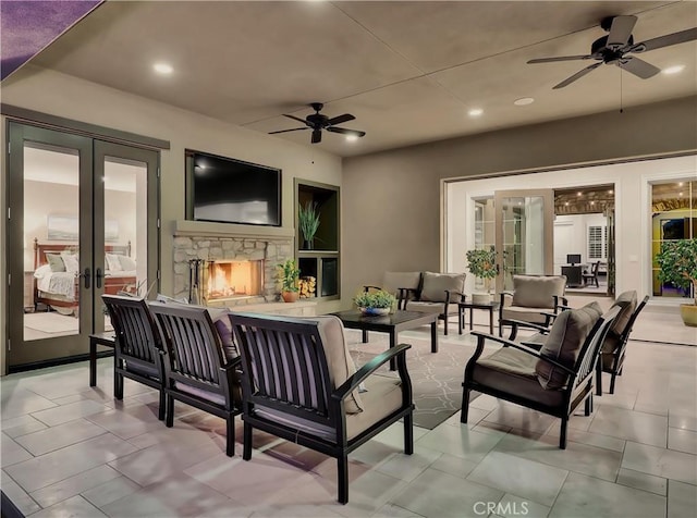 view of patio / terrace featuring an outdoor living space with a fireplace, french doors, and ceiling fan