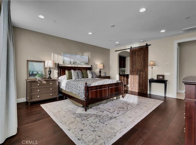bedroom with visible vents, a barn door, dark wood-style flooring, and recessed lighting