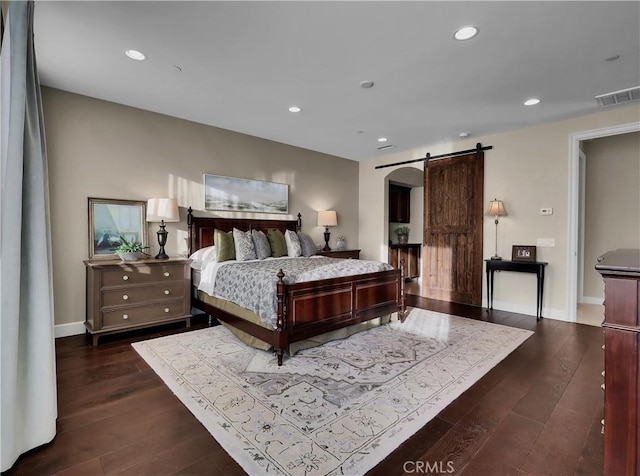 31801 Via Granada, San Juan Capistrano, CA 92675 - bedroom featuring a barn door, dark wood finished floors, recessed lighting, baseboards, and arched walkways