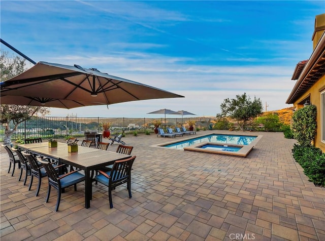 view of swimming pool with outdoor dining space, a patio, fence, a fenced in pool, and an in ground hot tub