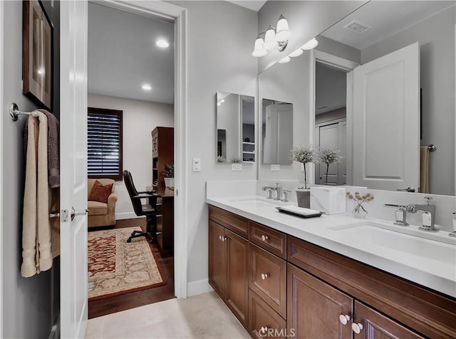 bathroom with ensuite bath, double vanity, visible vents, and a sink