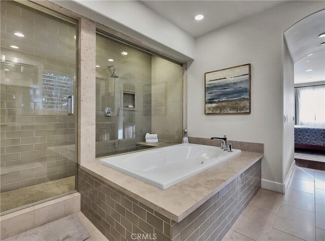 ensuite bathroom with tile patterned flooring, baseboards, recessed lighting, a bath, and a tile shower