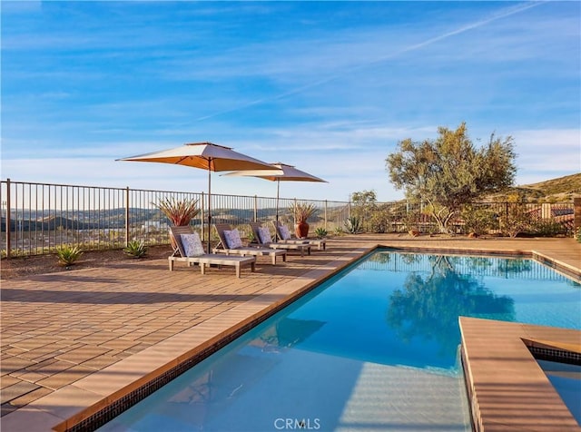 view of swimming pool with a fenced in pool, a patio, and fence