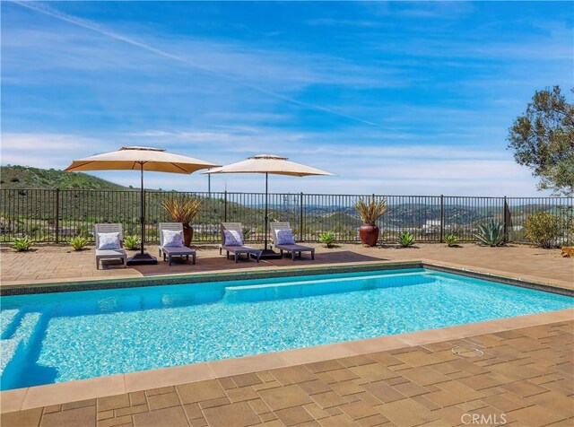 view of pool featuring fence, a fenced in pool, and a patio area