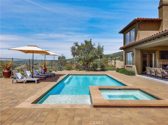 view of swimming pool featuring a fenced in pool, a fenced backyard, an in ground hot tub, and a patio area