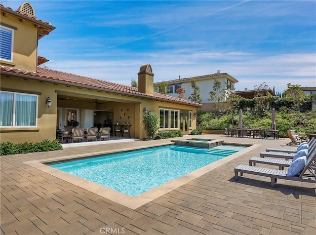 view of swimming pool featuring a patio, a pool with connected hot tub, and outdoor dining space