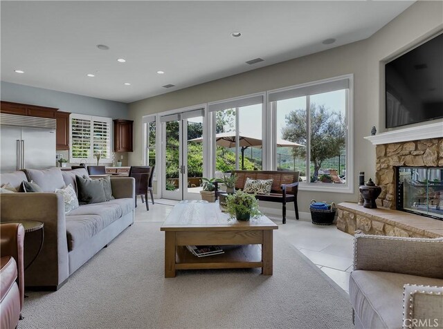 living area featuring light carpet, a fireplace, recessed lighting, baseboards, and visible vents