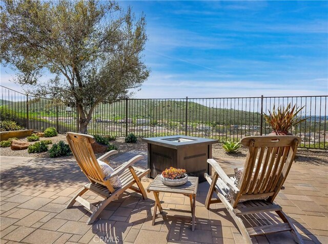view of patio / terrace with an outdoor fire pit and fence