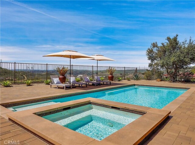 view of swimming pool featuring an in ground hot tub, a fenced in pool, and a fenced backyard