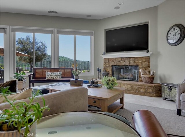 living area featuring visible vents and a fireplace