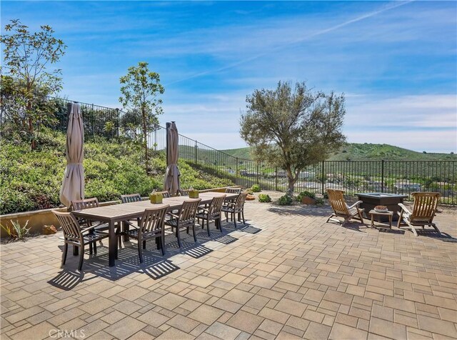 view of patio featuring a fire pit, fence, and outdoor dining space
