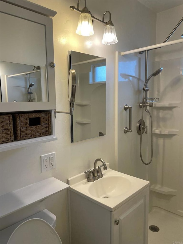 full bathroom featuring toilet, a stall shower, and vanity