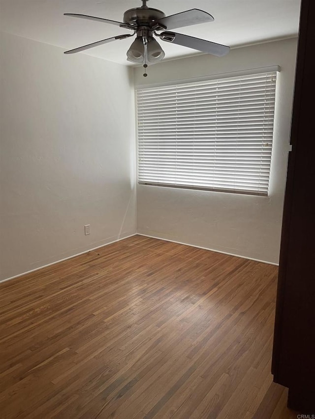 empty room featuring a ceiling fan and wood finished floors