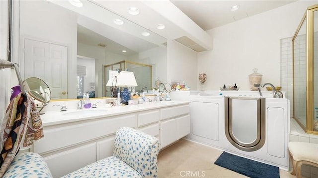 full bathroom featuring a garden tub, double vanity, a stall shower, and a sink