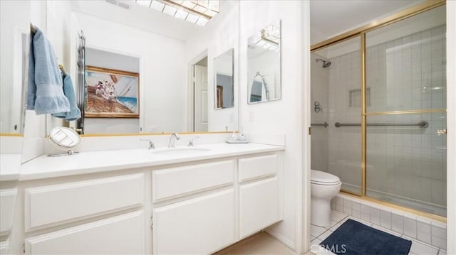 bathroom featuring vanity, tile patterned floors, toilet, and a stall shower