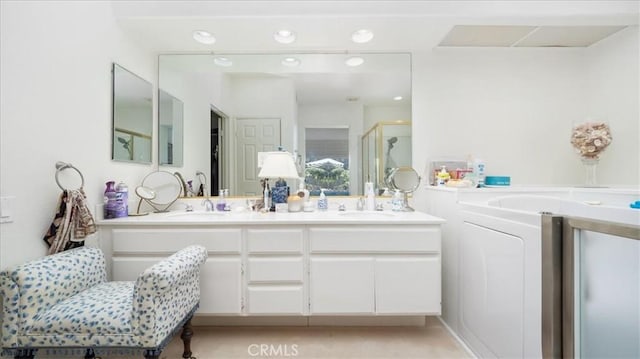 bathroom with a shower stall, a bath, double vanity, and a sink