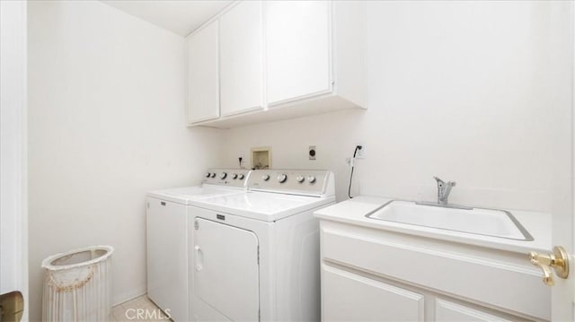 laundry room with washer and clothes dryer, cabinet space, and a sink